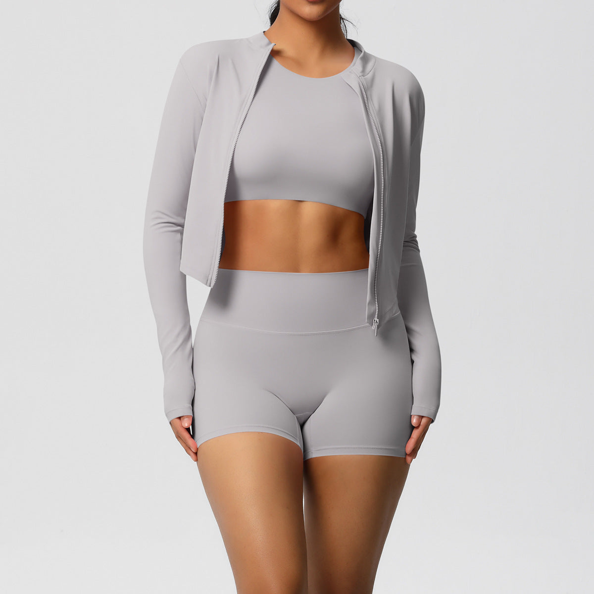 Person wearing a gray athletic outfit on a plain background